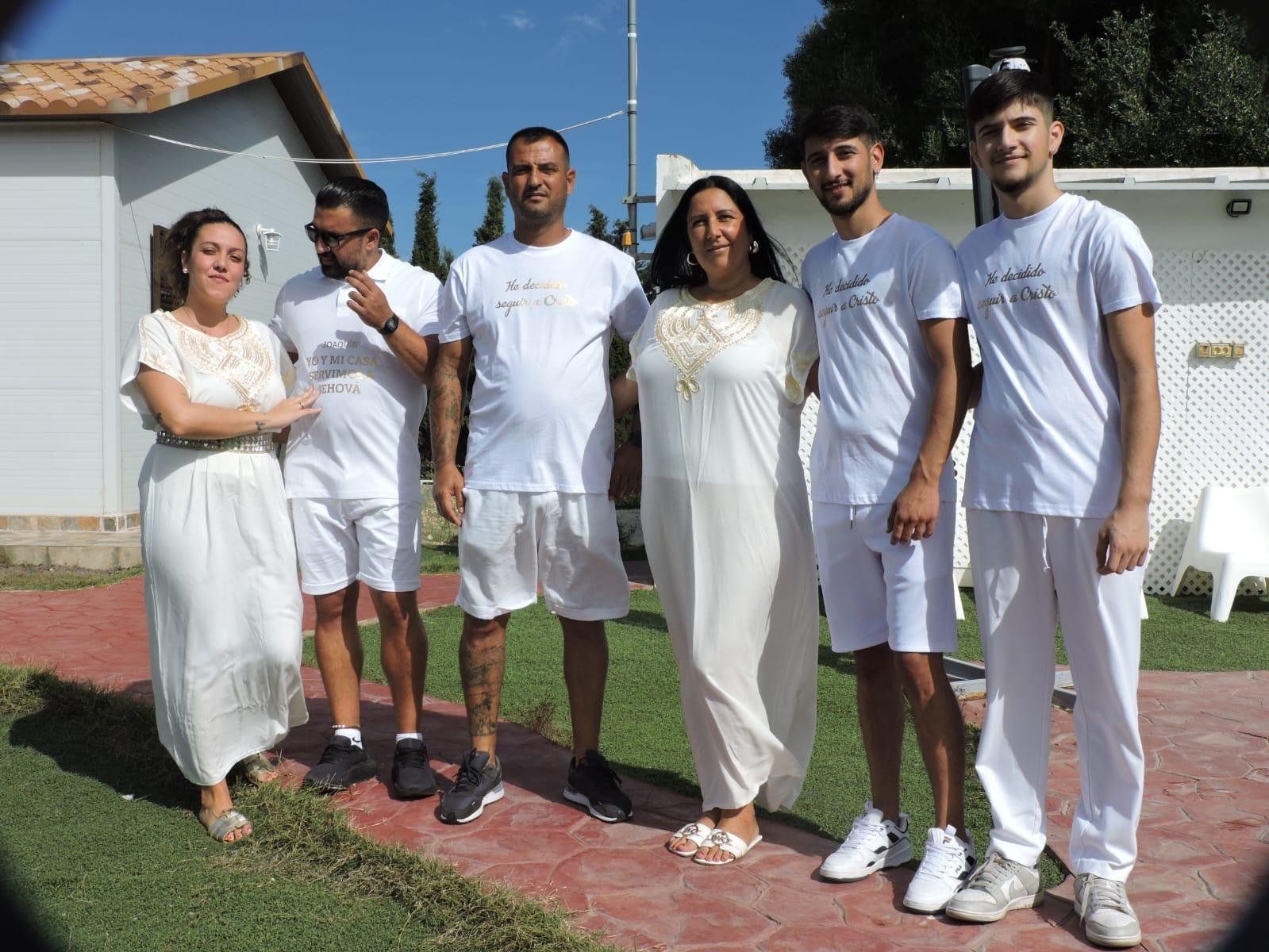Seis miembros de la iglesia con camisetas blancas con el lema «He decidido seguir a Cristo», posando en el jardín antes del bautismo